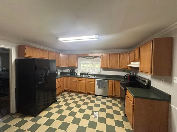 a kitchen with stainless steel appliances granite countertop a refrigerator and a sink