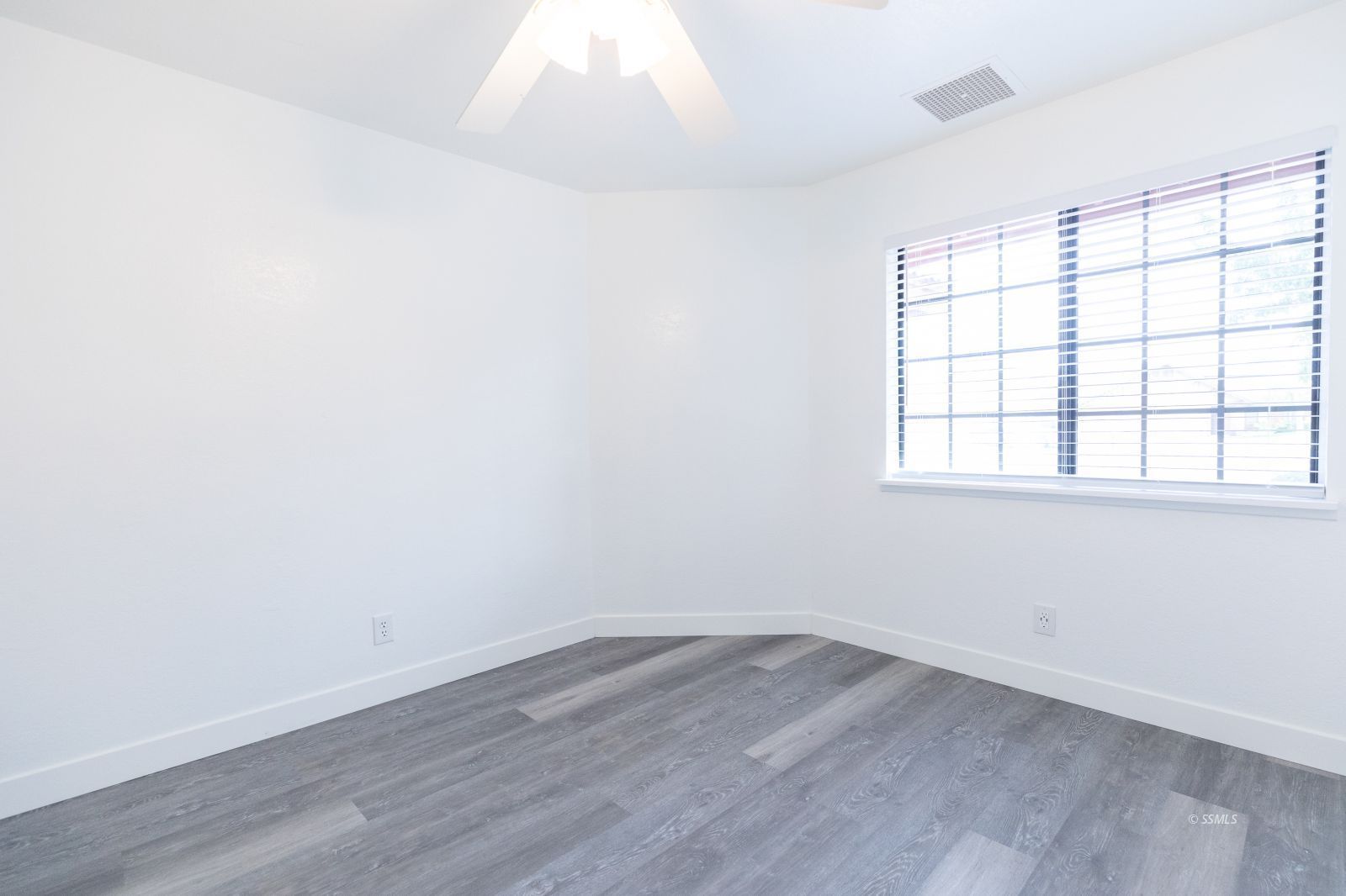 1133 Meadowview Lane Ridgecrest, CA 93555 - Photo 27 of 49 an empty room with wooden floor and windows