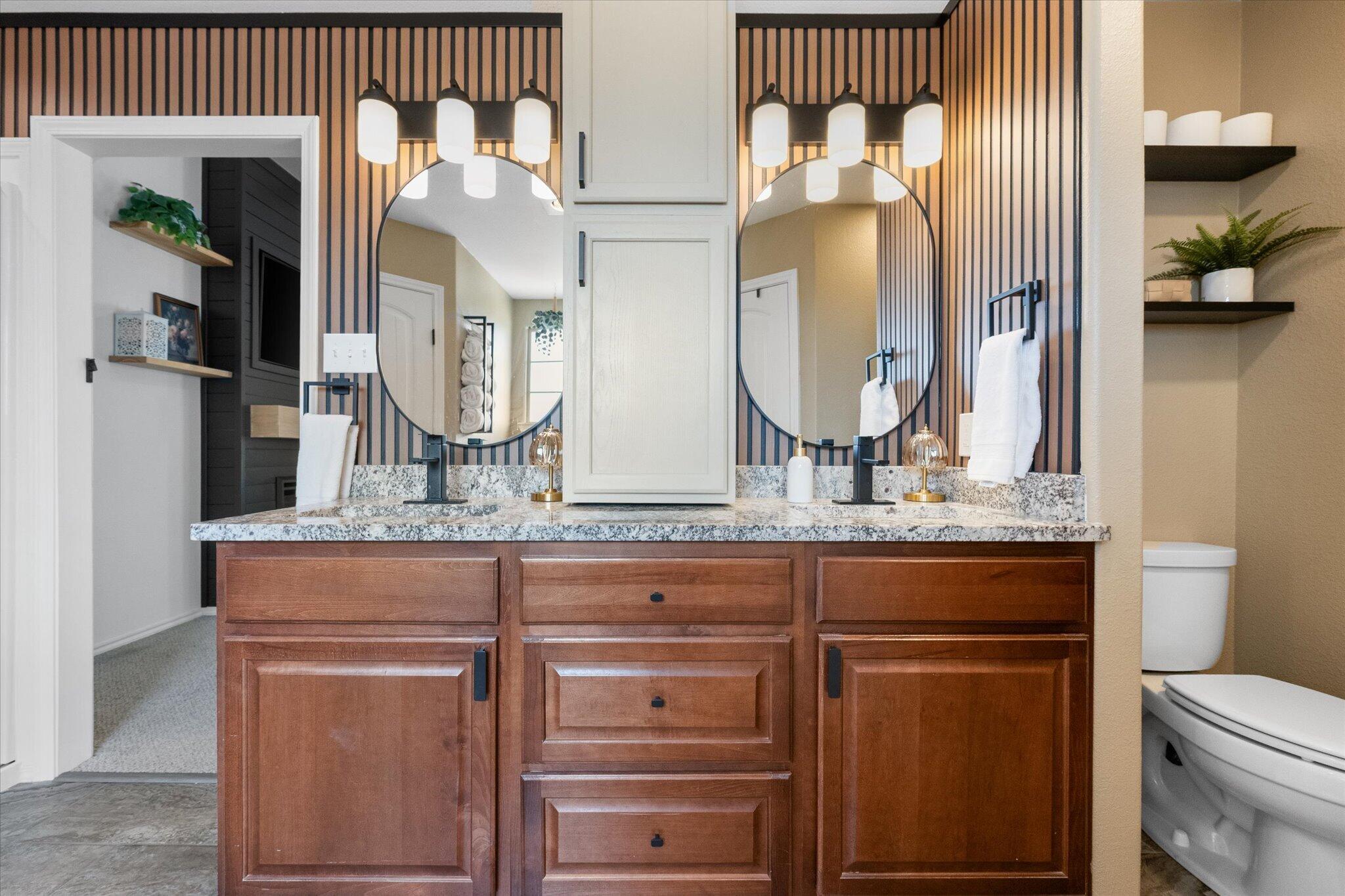 1429 Fm 211 Wilson, TX 79381 - Photo 28 of 43 a bathroom with a granite countertop toilet sink and mirror