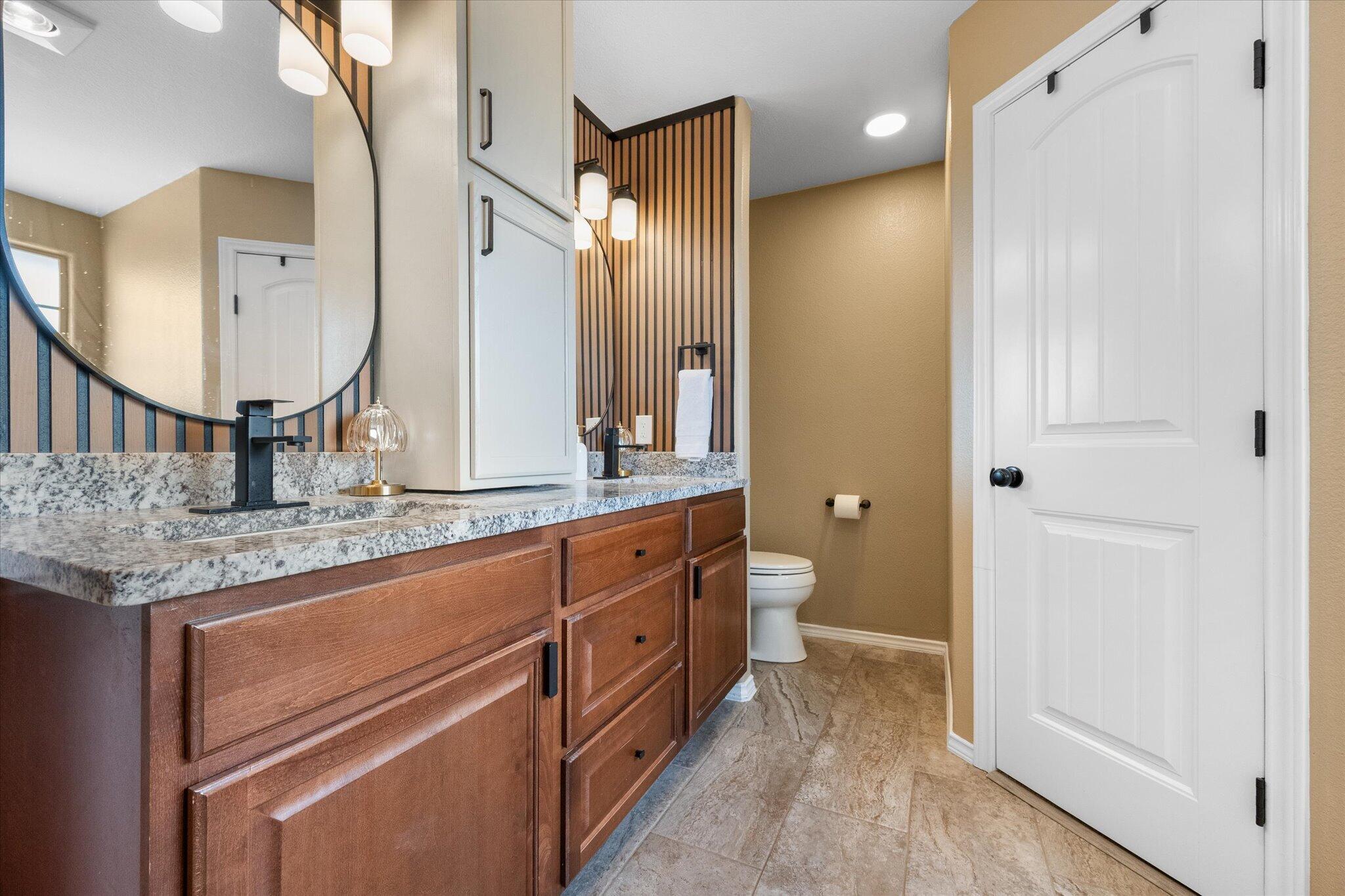 1429 Fm 211 Wilson, TX 79381 - Photo 30 of 43 a spacious bathroom with a granite countertop sink mirror and toilet