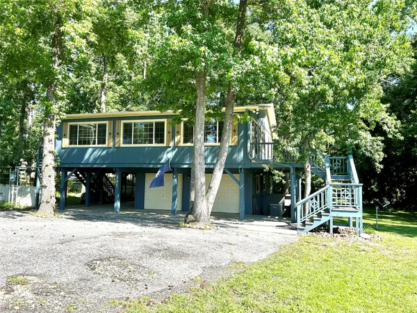 a view of a house with a yard and large trees