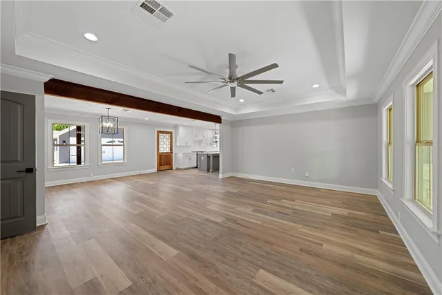 a view of an empty room with a window and wooden floor