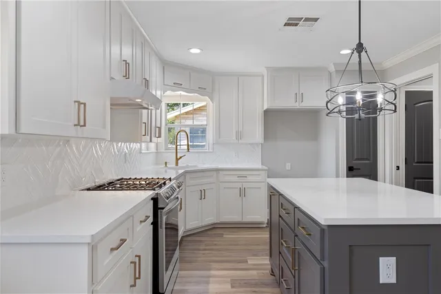 a kitchen that has a lot of cabinets in it and stainless steel appliances