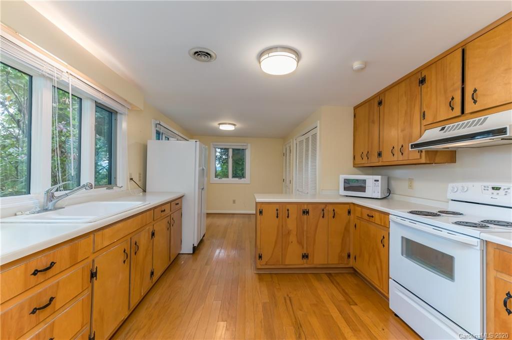 2468 Peniel Road Columbus, NC 28722 - Photo 37 of 47 a large kitchen with stainless steel appliances granite countertop a lot of counter space and wooden floors