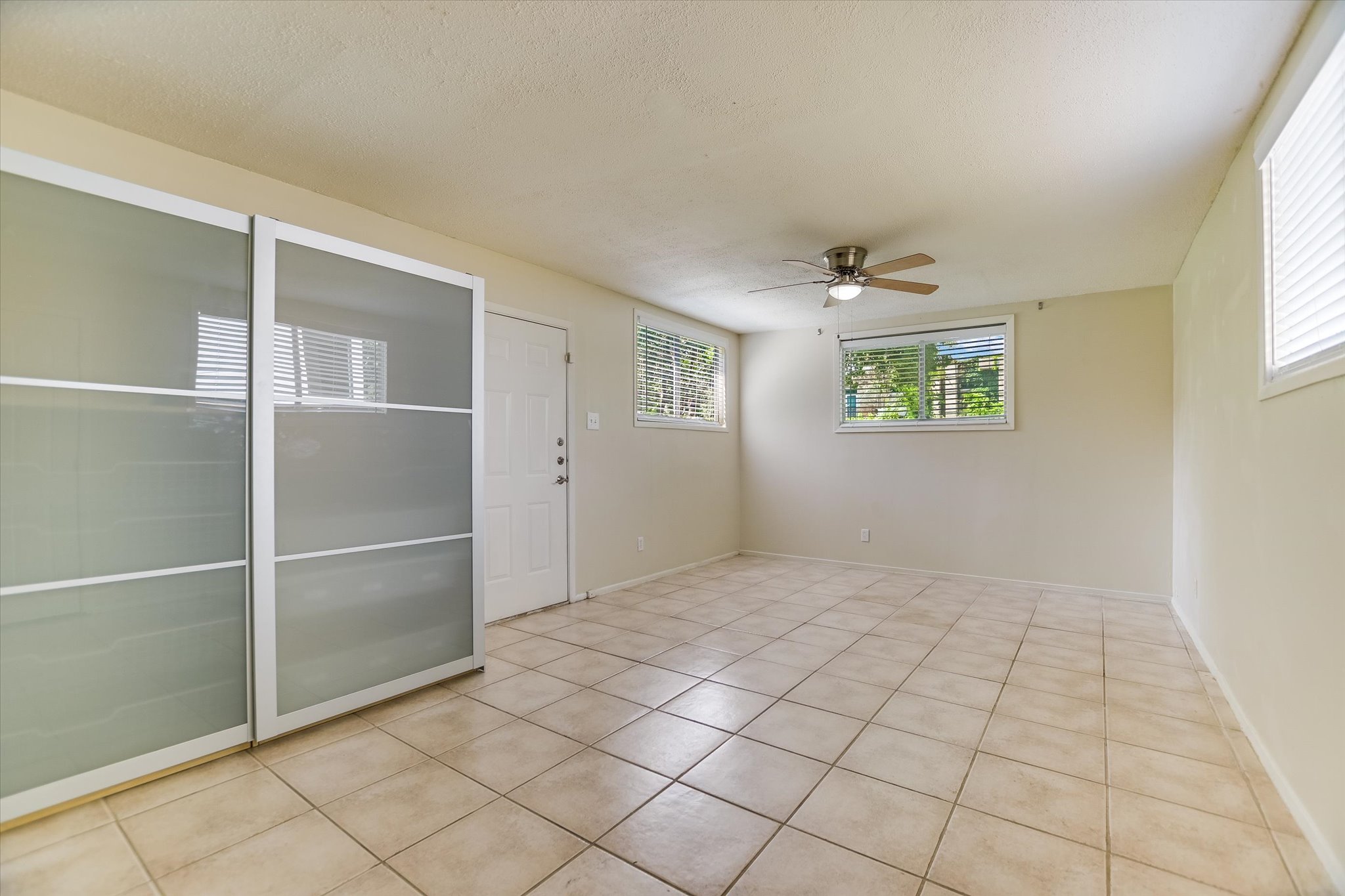 208 Braeswood Road Austin, TX 78704 - Photo 10 of 20 A spacious room offers durable tile flooring and multiple windows for abundant light.