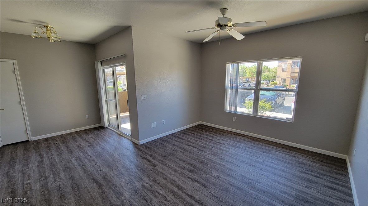 6650 West Warm Springs Road, Unit 1032 Las Vegas, NV 89118 - Photo 15 of 17 Unfurnished room featuring dark wood finished floors, ceiling fan, and a chandelier