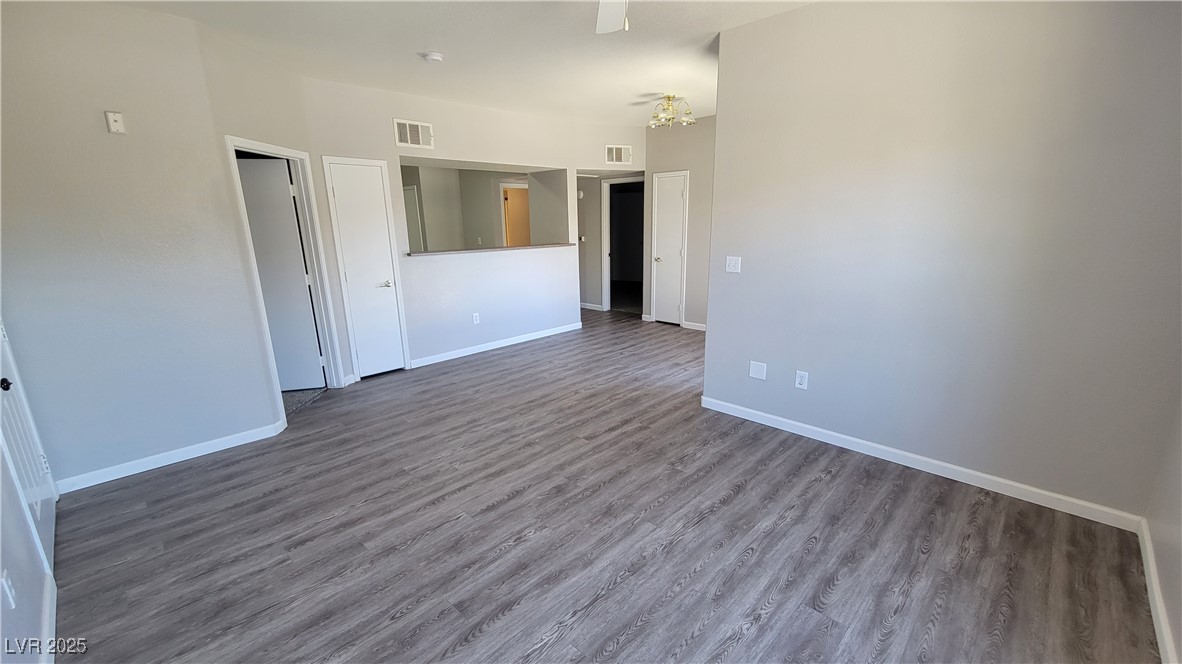 6650 West Warm Springs Road, Unit 1032 Las Vegas, NV 89118 - Photo 16 of 17 Empty room featuring wood finished floors and a chandelier
