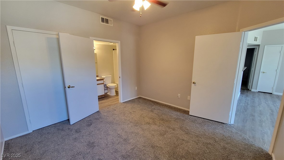 6650 West Warm Springs Road, Unit 1032 Las Vegas, NV 89118 - Photo 17 of 17 Unfurnished bedroom with carpet flooring, connected bathroom, and ceiling fan