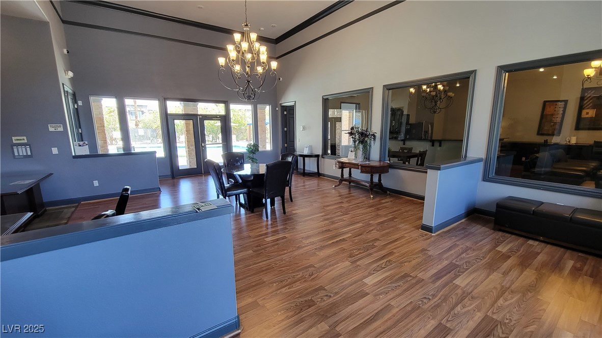 6650 West Warm Springs Road, Unit 1032 Las Vegas, NV 89118 - Photo 4 of 17 Living area with a high ceiling, a chandelier, dark wood-style flooring, and ornamental molding