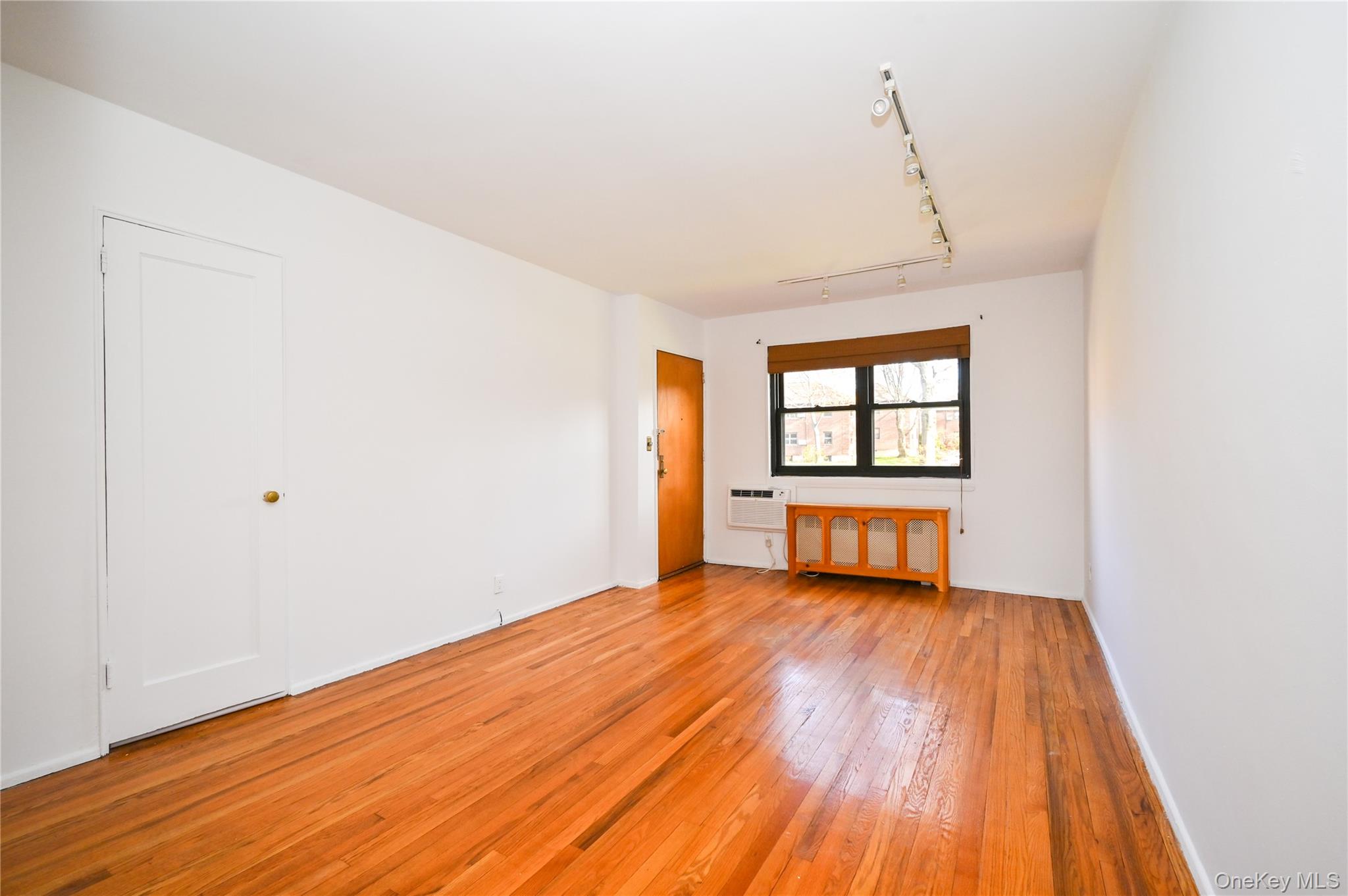 245-12 62nd Avenue, Unit G/3 LOWER Queens, NY 11362 - Photo 4 of 18 a view of a room with wooden floor and small window