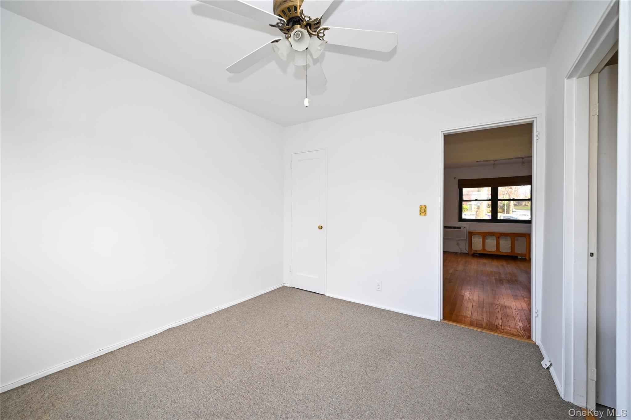 245-12 62nd Avenue, Unit G/3 LOWER Queens, NY 11362 - Photo 9 of 18 an empty room with chandelier fan and windows