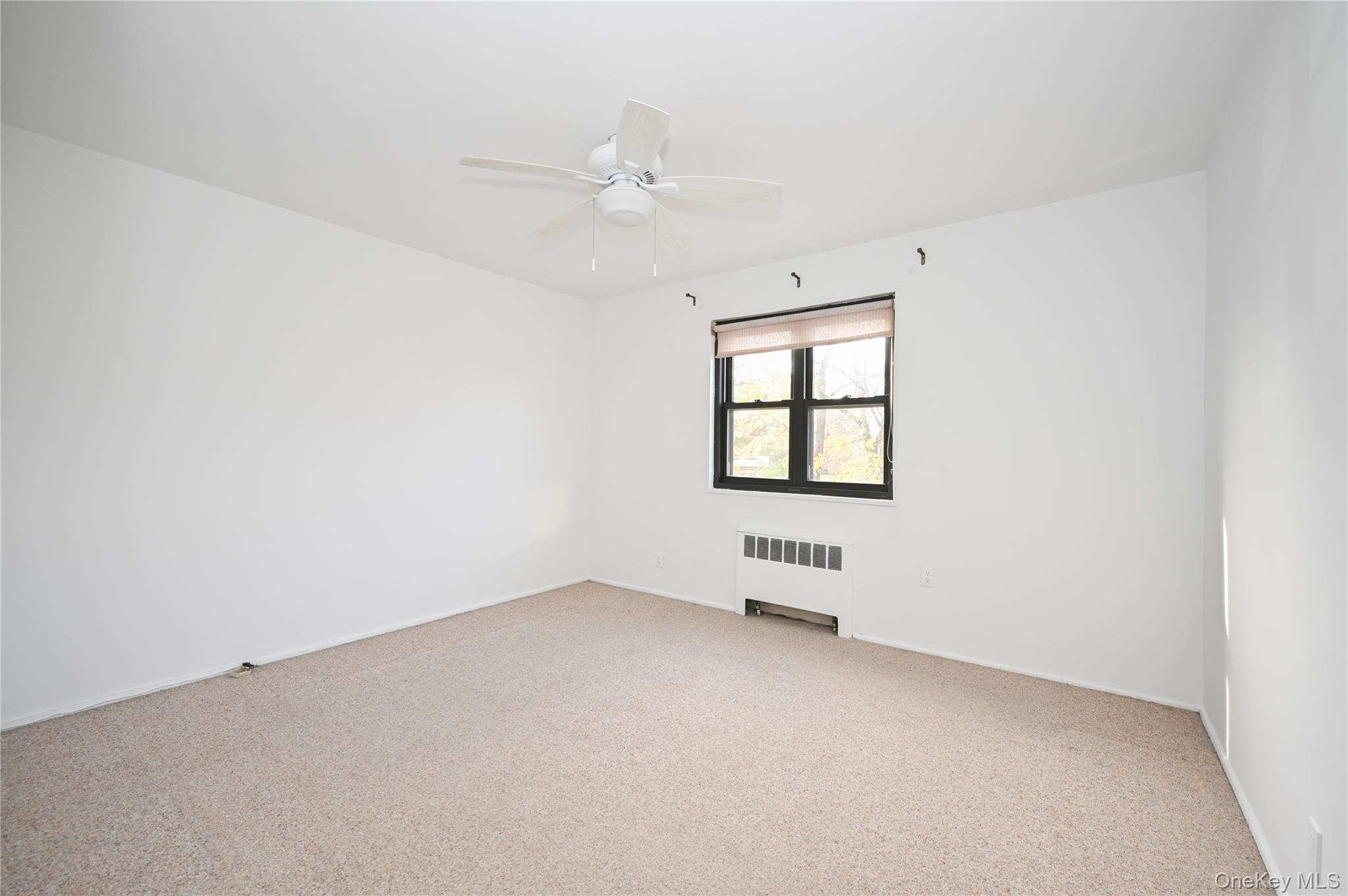 245-12 62nd Avenue, Unit G/3 LOWER Queens, NY 11362 - Photo 10 of 18 an empty room with windows and fan