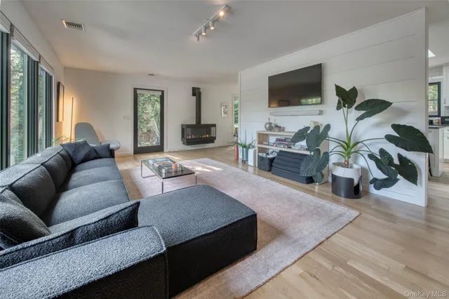 a living room with furniture flat screen tv and wooden floor