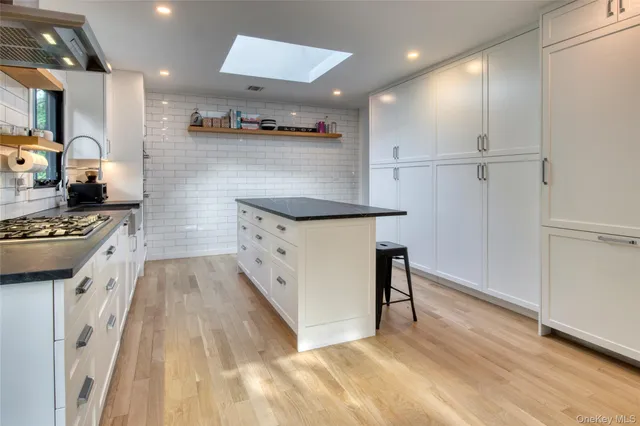 a kitchen with granite countertop a sink appliances and cabinets