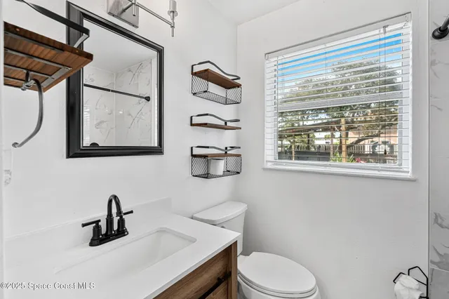 an empty room with a window and a ceiling fan