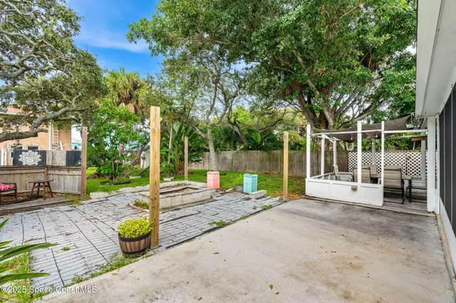 a view of a backyard with table and chairs and a large tree