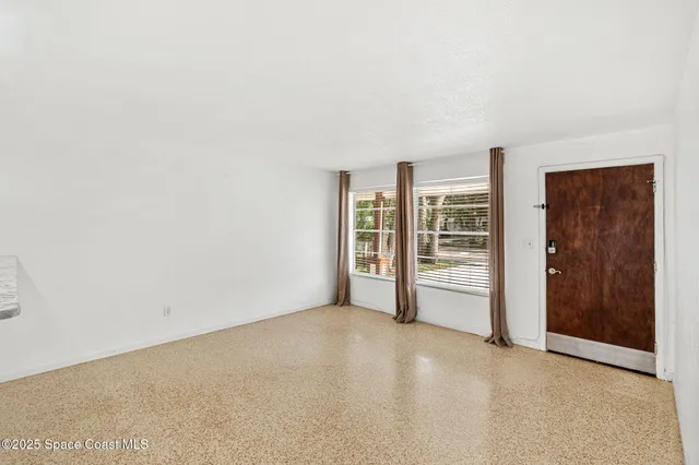 an empty room with closet and windows