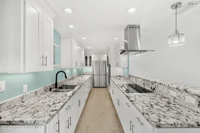 a large kitchen with stainless steel appliances granite countertop a large counter top and a stove