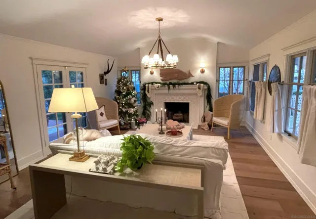 a living room with furniture a fireplace and a chandelier