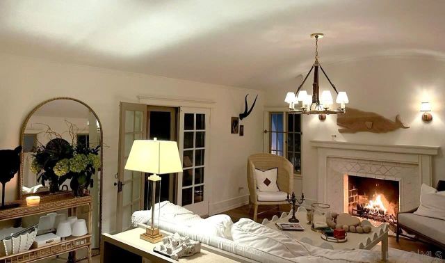 a living room with furniture chandelier and a fireplace