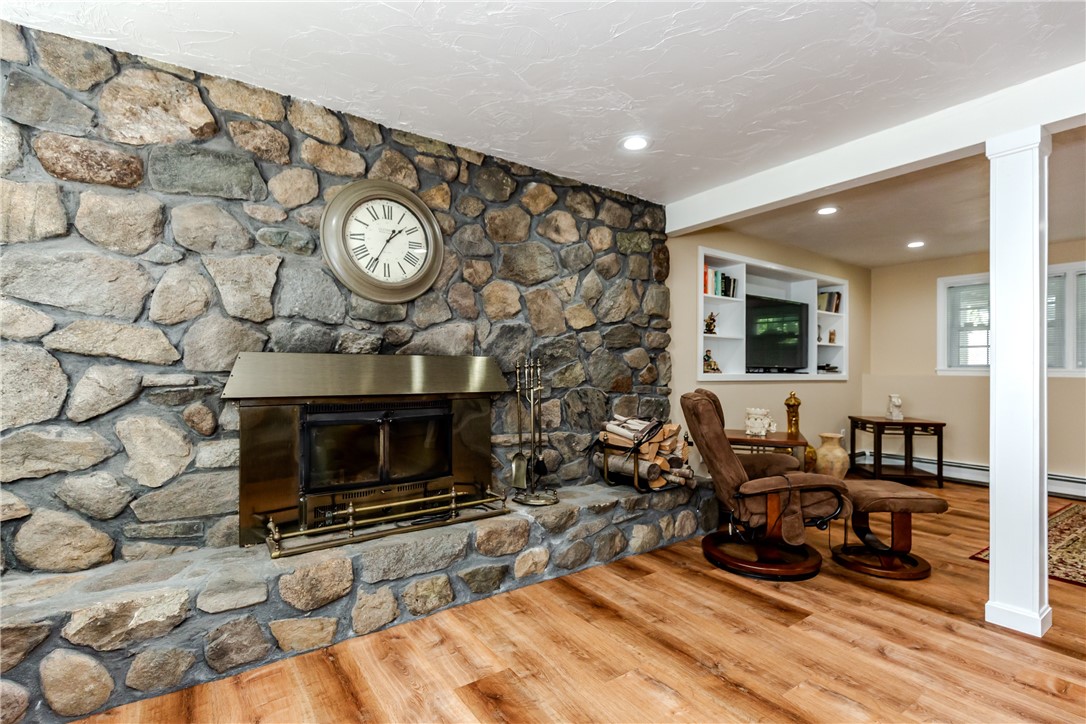 99 Tower Hill Road Cumberland, RI 02864 - Photo 26 of 43 Beautiful wood-burning fireplace creating a warm and inviting atmosphere.