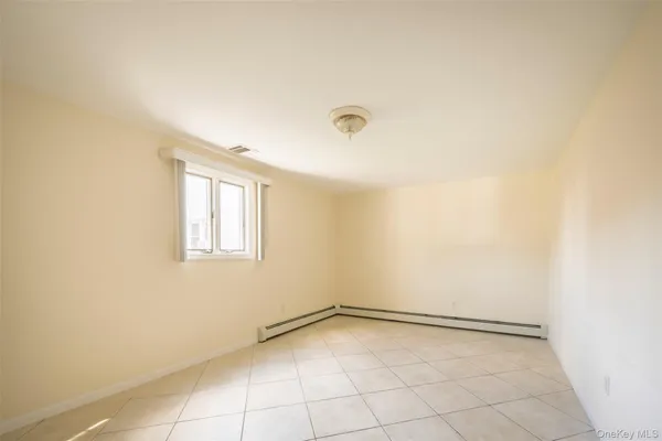 a view of a hallway with wooden floor and a bathroom