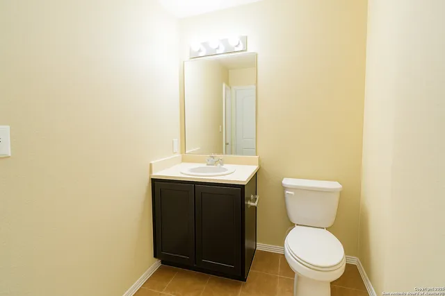 a bathroom with a toilet sink vanity and mirror