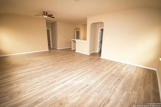 an empty room with wooden floor and a window