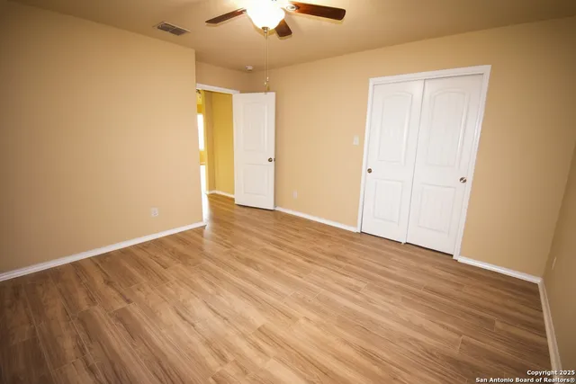 a view of an empty room with wooden floor