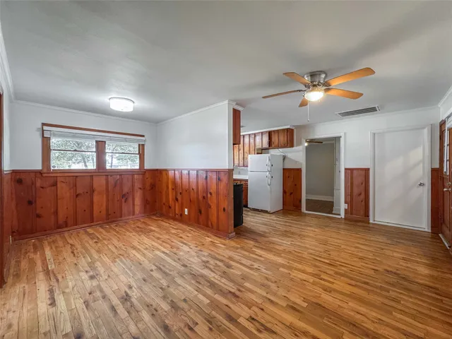 a view of a livingroom with wooden floor and a ceiling fan