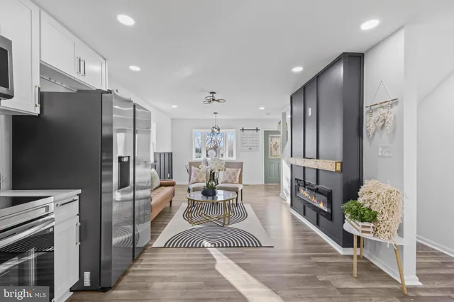 a kitchen with stainless steel appliances kitchen island granite countertop a refrigerator a stove and a cabinets with wooden floor