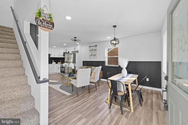 a living room with stainless steel appliances furniture a dining table and chairs
