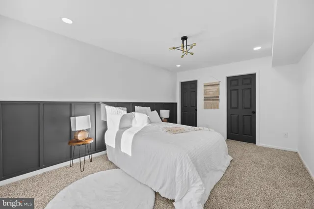 a bedroom with a large bed and a chandelier