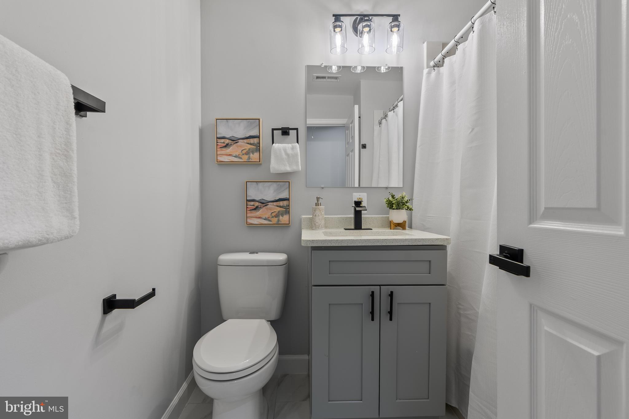 10021 Fox Den Road Ellicott City, MD 21042 - Photo 21 of 41 a bathroom with a granite countertop sink a toilet and a shower