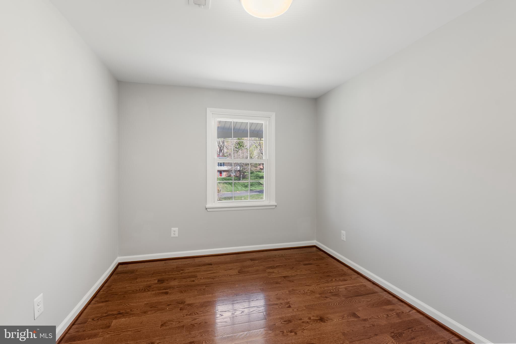 10021 Fox Den Road Ellicott City, MD 21042 - Photo 22 of 41 an empty room with wooden floor and windows