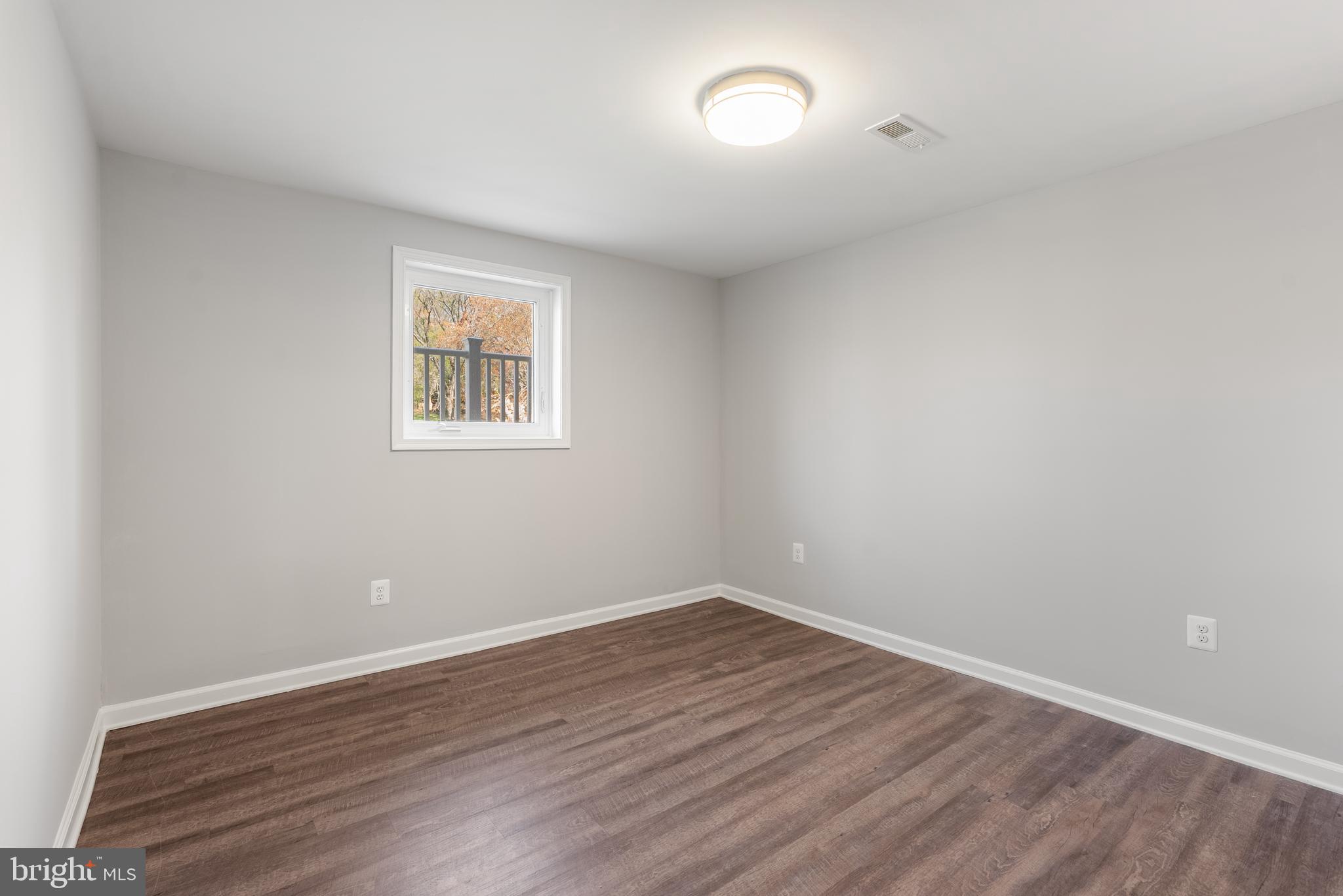 10021 Fox Den Road Ellicott City, MD 21042 - Photo 24 of 41 an empty room with wooden floor and windows