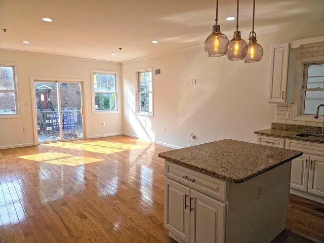 a kitchen with a stove a sink a counter space and a window