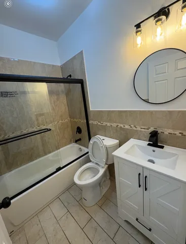 a kitchen with stainless steel appliances granite countertop a stove a sink dishwasher a refrigerator and white cabinets with wooden floor