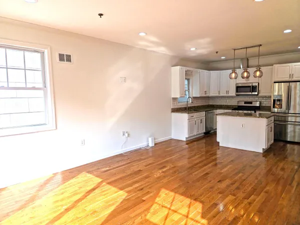 a kitchen with stainless steel appliances granite countertop a stove a sink and a refrigerator