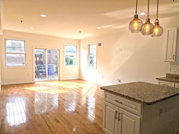 a kitchen with stainless steel appliances granite countertop a refrigerator a stove and a wooden floors