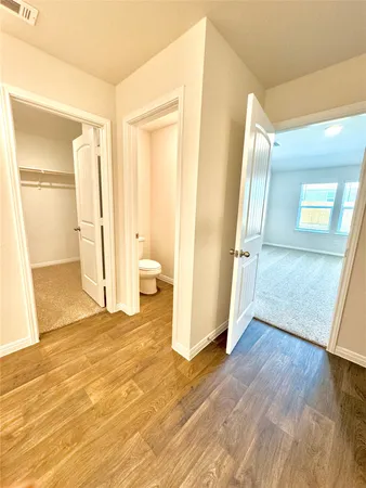 a view of empty room with wooden floor and window