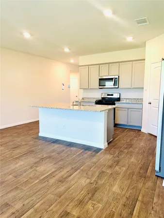 a kitchen with stainless steel appliances a sink a stove a refrigerator cabinets and a counter top space