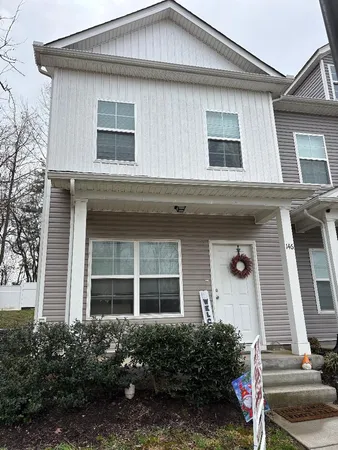 a front view of a house with plants