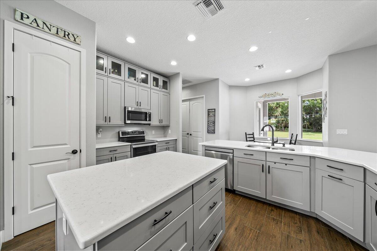 3490 Grant Line Road Mims, FL 32754 - Photo 11 of 43 a kitchen with a sink stainless steel appliances and white cabinets