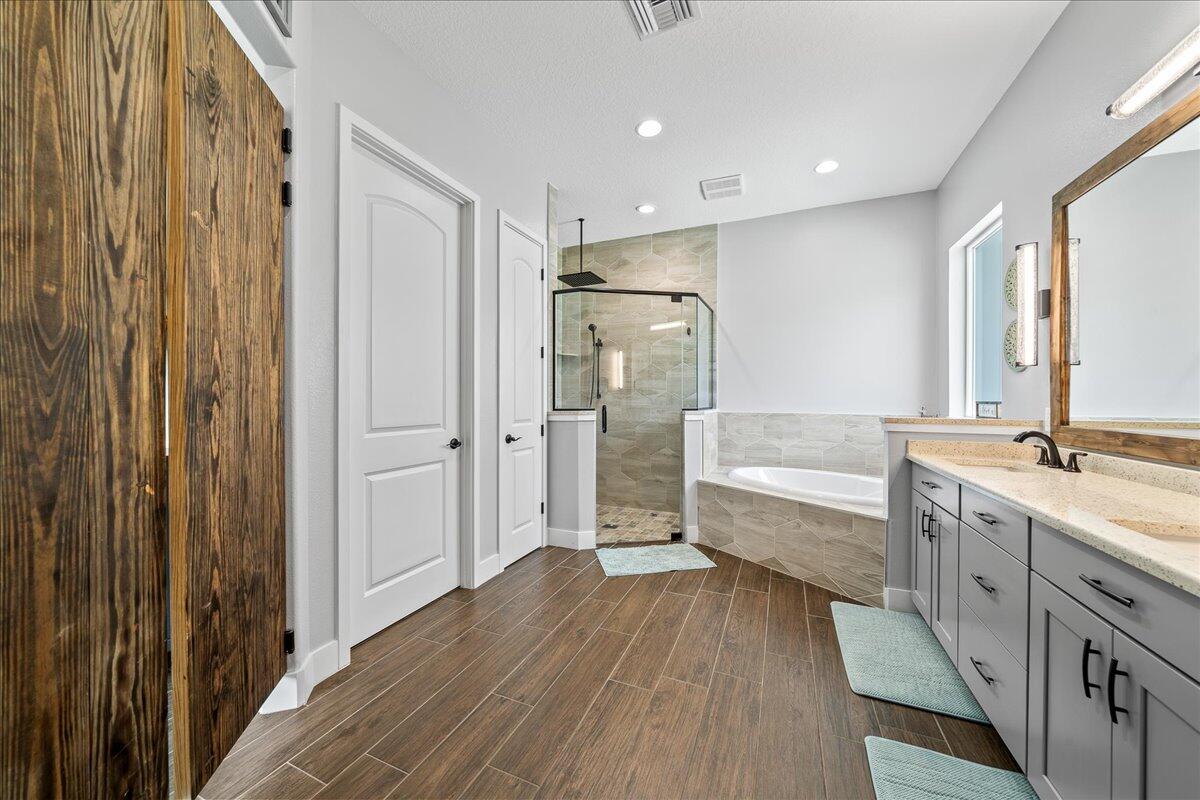 3490 Grant Line Road Mims, FL 32754 - Photo 15 of 43 a bathroom with a double vanity sink a mirror and a bathtub