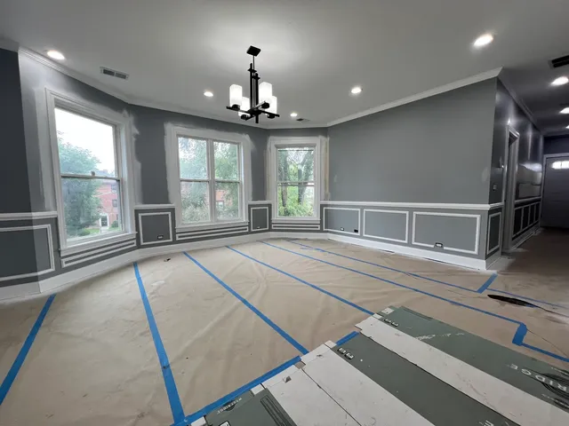 a spacious bedroom with a large bed and a chandelier