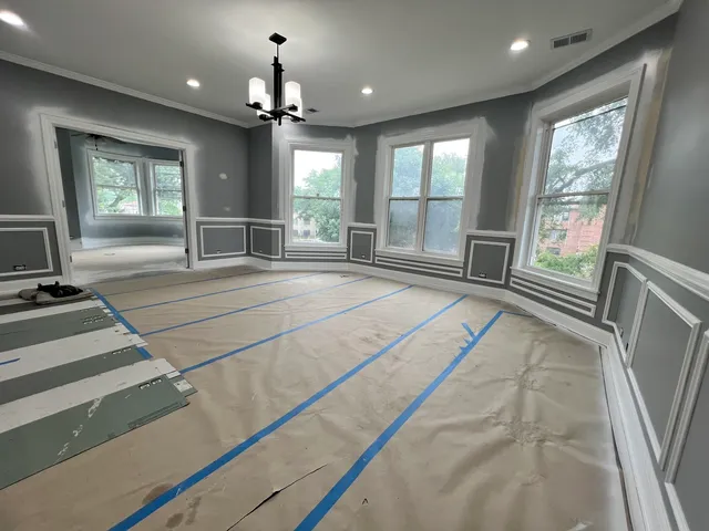 a spacious bedroom with a large bed and a chandelier