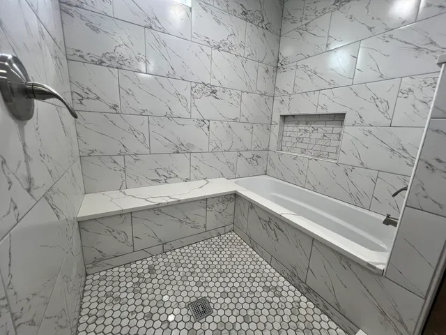 a bathroom with a bathtub and shower