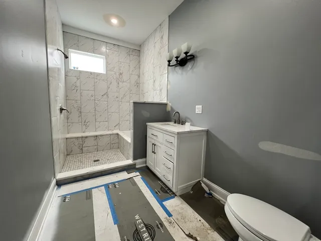 a bathroom with a sink a toilet and shower