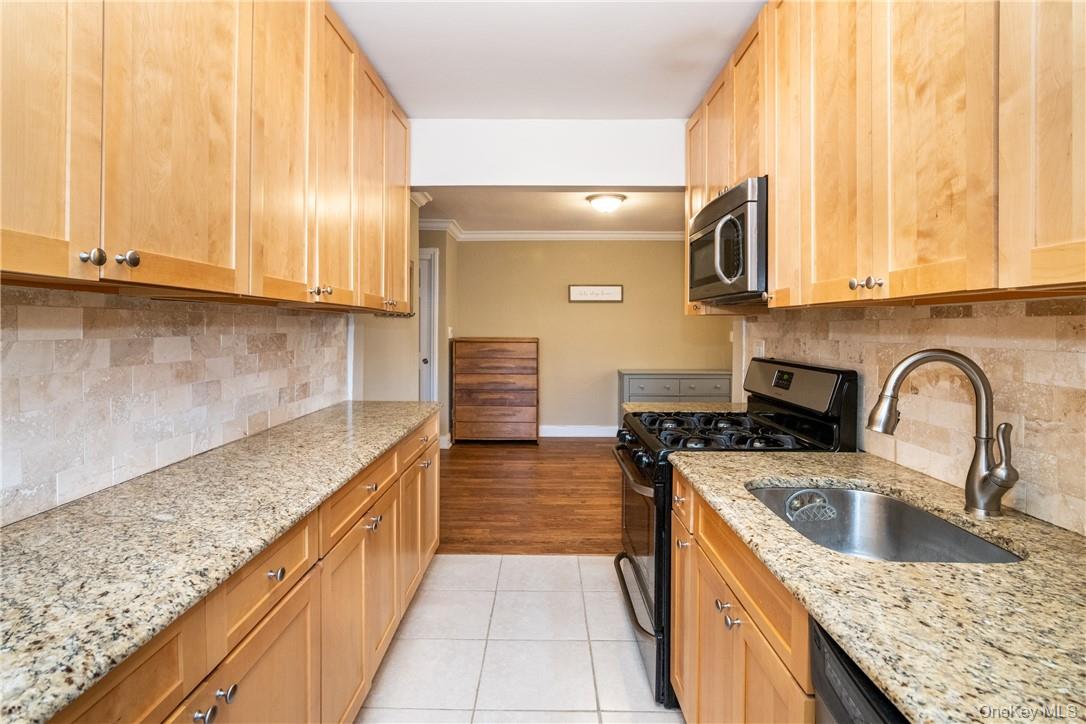 50 White Oak Street, Unit 3G New Rochelle, NY 10801 - Photo 11 of 16 a kitchen with stainless steel appliances granite countertop a sink a stove and cabinets